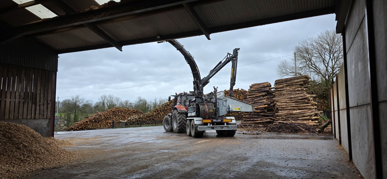 Chipper working through timber for biomass feedstock processing