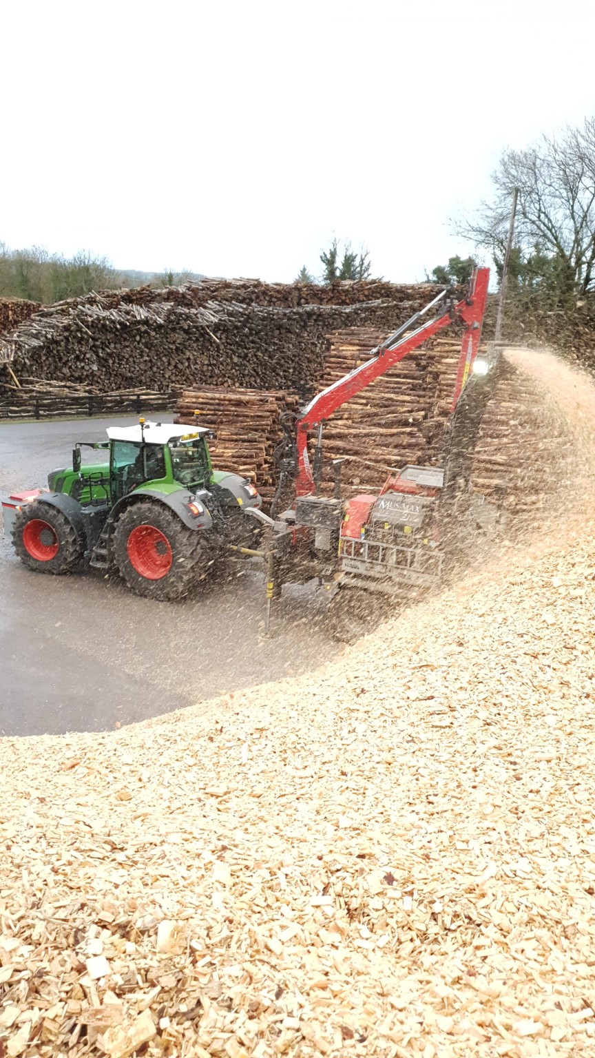Contract chipping machinery processing biomass feedstock